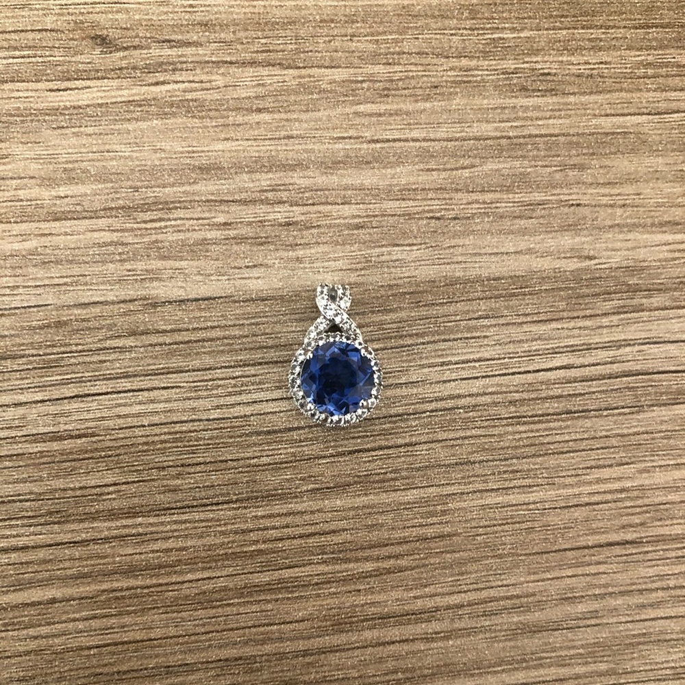 Blue sapphire pendant with white topaz accents.